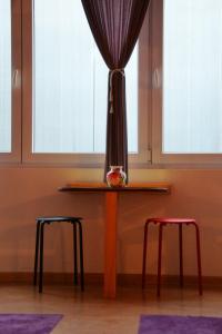 a table with two stools in front of a window at Skopje Hostel in Skopje