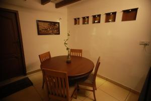 a dining room with a wooden table and chairs at Rampart Apartments in Cochin