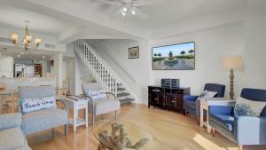 a living room with a table and chairs and a staircase at 401 A Shipwatch by AvantStay Beachfront Condo w Community Pool Access in Isle of Palms