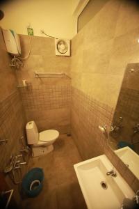 a small bathroom with a toilet and a sink at Rampart Apartments in Cochin