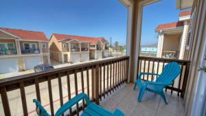 un portico con due sedie e un balcone con case di Sleeps 29 3 Homes Beachside Resort Pool Walk to the Beach a Port Aransas