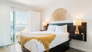 a bedroom with a bed with a view of the ocean at 2 Cayucan Bungalows Steps to Beach Shared Lounge Sleeps 12 in Cayucos