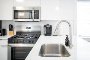 una cucina con lavandino, piano cottura e forno a microonde di Modern & Spacious Midtown Comfort with Walk Score 93 ad Atlanta