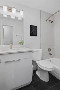 e bagno bianco con servizi igienici, lavandino e vasca. di Modern & Spacious Midtown Comfort with Walk Score 93 ad Atlanta Altre 44 foto