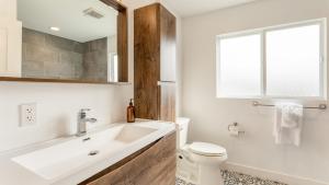 ein Badezimmer mit Waschbecken und Toilette und einem Fenster in der Unterkunft Velvet Sand I by AvantStay Steps to Newport Beach Private Rooftop w Outdoor Kitchen Hot Tub in Newport Beach + 32 Fotos
