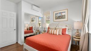 a bedroom with a bed with orange sheets and pillows at Makaha Villa by AvantStay Mountain Ocean Views in Waianae +50 photos