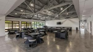 a large room with tables and chairs and windows at Makaha Villa by AvantStay Mountain Ocean Views in Waianae