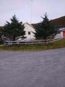 a white fence in front of a white house at Twin trees in Skarsvåg
