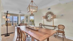Una sala de estar con una mesa y sillas de madera. en 303A Shipwatch by AvantStay Ocean View Shared Pool Boardwalk to Beach, en Isle of Palms 18 fotos más