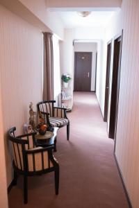 a hallway with three chairs and a table in a room at Villa Anticus (Adults Only) in Constanţa