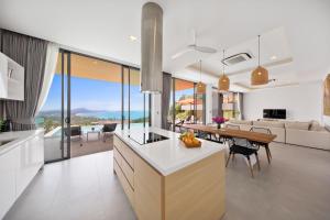 a kitchen and living room with a view of the ocean at Villa Fanta Sea - Luxury Residence at Chaweng Noi in Koh Samui 