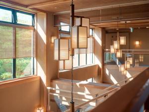 函館市にあるTabist 竹葉新葉亭 函館 湯の川温泉の階段と窓のある廊下