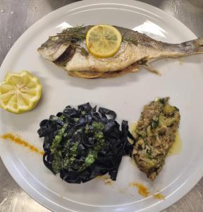 einen Teller mit Fisch und Gemüse in der Unterkunft Auberge les rastels in Savournon