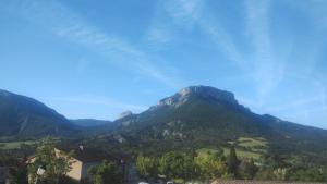 a view of a mountain range with trees and houses at Auberge les rastels in Savournon