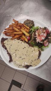 ein Teller mit Essen mit Pommes Frites und Fleisch mit Soße in der Unterkunft Auberge les rastels in Savournon