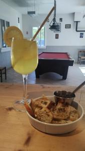 einen Drink in einem Glas neben einem Teller mit Essen in der Unterkunft Auberge les rastels in Savournon + 19 Fotos