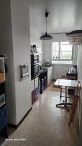 CourcouronnesにあるChambre 1 Personneの部屋の中央にテーブルがあるキッチン