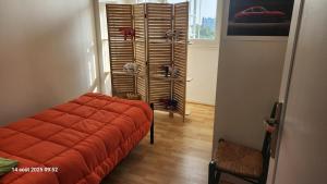 CourcouronnesにあるChambre 1 Personneの窓付きの客室で、オレンジ色のソファが備わります。