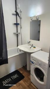 CourcouronnesにあるChambre 1 Personneの洗濯機と洗面台を備えたバスルーム