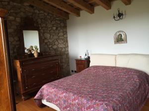 een slaapkamer met een bed, een dressoir en een spiegel bij Holiday House Petrarca in Arqua Petrarca
