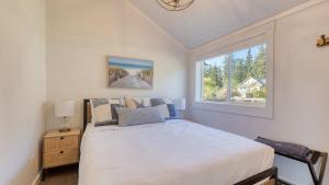 una camera da letto con un letto bianco e una finestra di Cozy Whidbey Island Stay Steps on the beach Fireplace BBQ Near Trails a Freeland