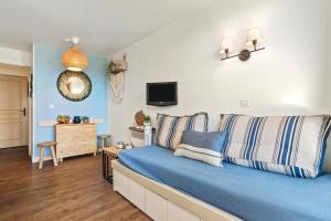 a bedroom with a blue bed and a tv at La Bohême in Grimaud