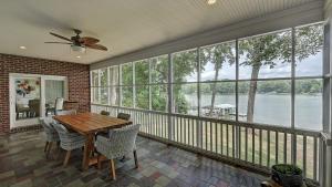 a screened in porch with a wooden table and chairs at Luckys Lake House by AvantStay Private Lake Bar in Mooresville