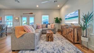 a living room with a couch and a flat screen tv at Priv Pool Yard w Putting Green Newly Remodeled Always Sunny by AvantStay in Port Aransas