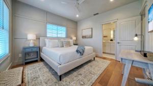 a bedroom with a white bed and a bathroom at Priv Pool Yard w Putting Green Newly Remodeled Always Sunny by AvantStay in Port Aransas +76 photos