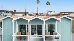 una casa con portico bianco e tetto di Topside Newport Rooftop Balcony Ocean Views Walk to Pier Marina Village a Newport Beach