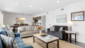 un soggiorno con un divano e un tavolo di Topside Newport Rooftop Balcony Ocean Views Walk to Pier Marina Village a Newport Beach