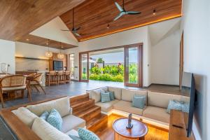 ein offenes Wohnzimmer mit Couch und Küche in der Unterkunft Villa Domus - B4 in Sanur