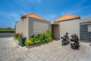 zwei Motorräder, die vor einem Haus geparkt sind in der Unterkunft Villa Domus - B4 in Sanur