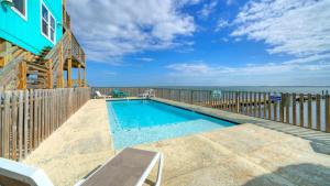 a swimming pool on a deck with the ocean in the background at Pool Access Boat Dock Steps to the Gulf The Pintail by AvantStay in Padre Island