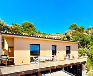 a house on a deck with chairs on it at Domaine RABOLY - Beaumes de Venise in Beaumes-de-Venise