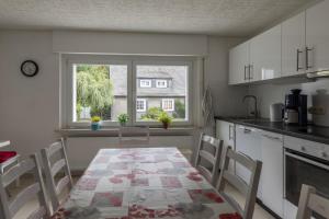 Una cocina con mesa y sillas y una ventana. en Ferienhäuser Bergfreiheit, en Winterberg