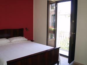 een slaapkamer met een bed en een glazen schuifdeur bij B&B Mamma Elena in Rovito
