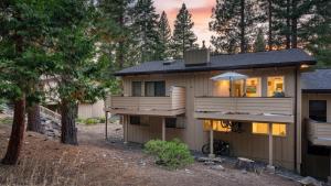 Una casa en el bosque con el sol brillando sobre ella. en Tahoe Dreamin’ by AvantStay Central Location, en Incline Village