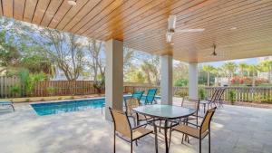 a patio with a table and chairs and a pool at 616 Carolina Boulevard by AvantStay Ocean Views from Decks in Mount Pleasant