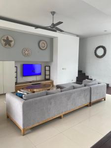 a living room with a couch and a flat screen tv at Mai Villa Umalas in Canggu