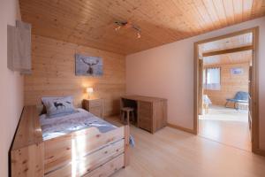 a bedroom with a bed and a wooden wall at Gîte La Clé Des Champs in Manigod