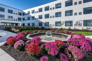 a building with flowers in front of a fountain at Cambria Hotel Portland Downtown Old Port in Portland