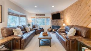 un soggiorno con divano in pelle e camino di Westlake Cabin by AvantStay Hot Tub Near Skiing Walk to Restaurants Lake a Tahoe City