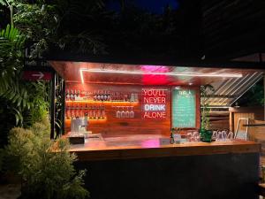 a bar with a sign that reads you never drink alone at Chern Chiangmai Boutique Hotel in Chiang Mai