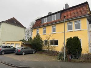 zwei Autos parkten vor einem gelben Haus in der Unterkunft Stilvolle Suite in Celle - Frühstück, Kaffee, kostenloser Parkplatz und Wohnküche in Celle