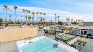einen Whirlpool auf einem Balkon mit Palmen in der Unterkunft Velvet Sand Buyout by AvantStay Steps to Newport Beach Sleeps 22 in Newport Beach
