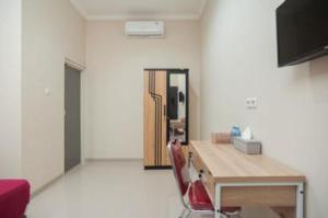 a room with a desk and a red chair at Hanna Residence near RSPI Puri Indah Mitra RedDoorz in Meruya-hilir