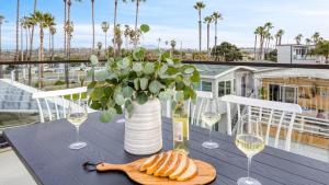 einen Tisch mit Weingläsern und eine Vase Blumen in der Unterkunft Velvet Sand Buyout by AvantStay Steps to Newport Beach Sleeps 22 in Newport Beach
