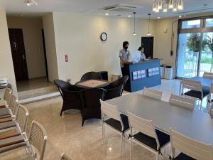 two people standing in a room with a table and chairs at HOTEL PAIKAJI - Vacation STAY 52789v in Ishigaki Island