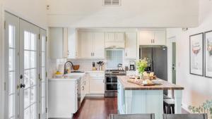 eine Küche mit weißen Schränken und einer Holzarbeitsplatte in der Unterkunft Hilltop by AvantStay Countryside Escape w Views in Paso Robles